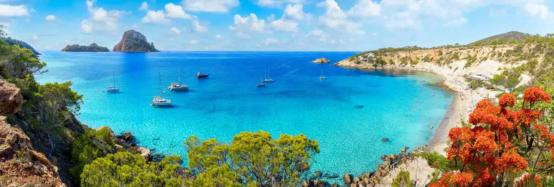 Panoramic views of the Mediterranean waters around the Balearic Islands with the famous Es Vedrà rock on the horizon, revealing Ibiza as one of the most luxurious vacation destinations.