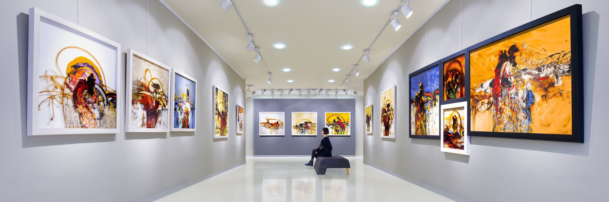 In a art gallery young woman visits an art exhibition and watches artist's collection.