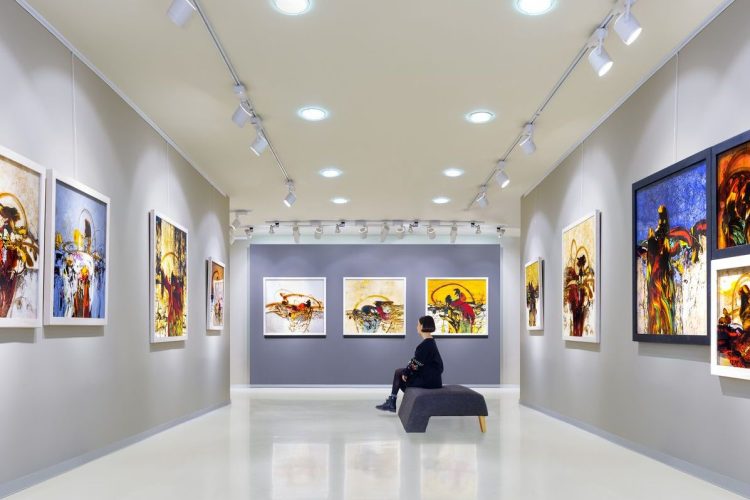 In a art gallery young woman visits an art exhibition and watches artist's collection.