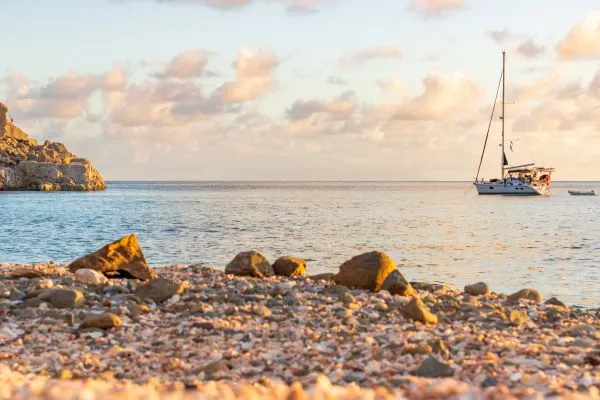 Yacht ancré au coucher de soleil sur une plage de Saint-Barth, expérience inoubliable des meilleures destinations pour Thanksgiving.